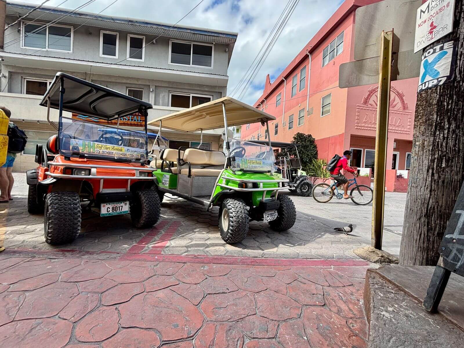 A lineup of J&H rental golf carts along a San Pedro street
