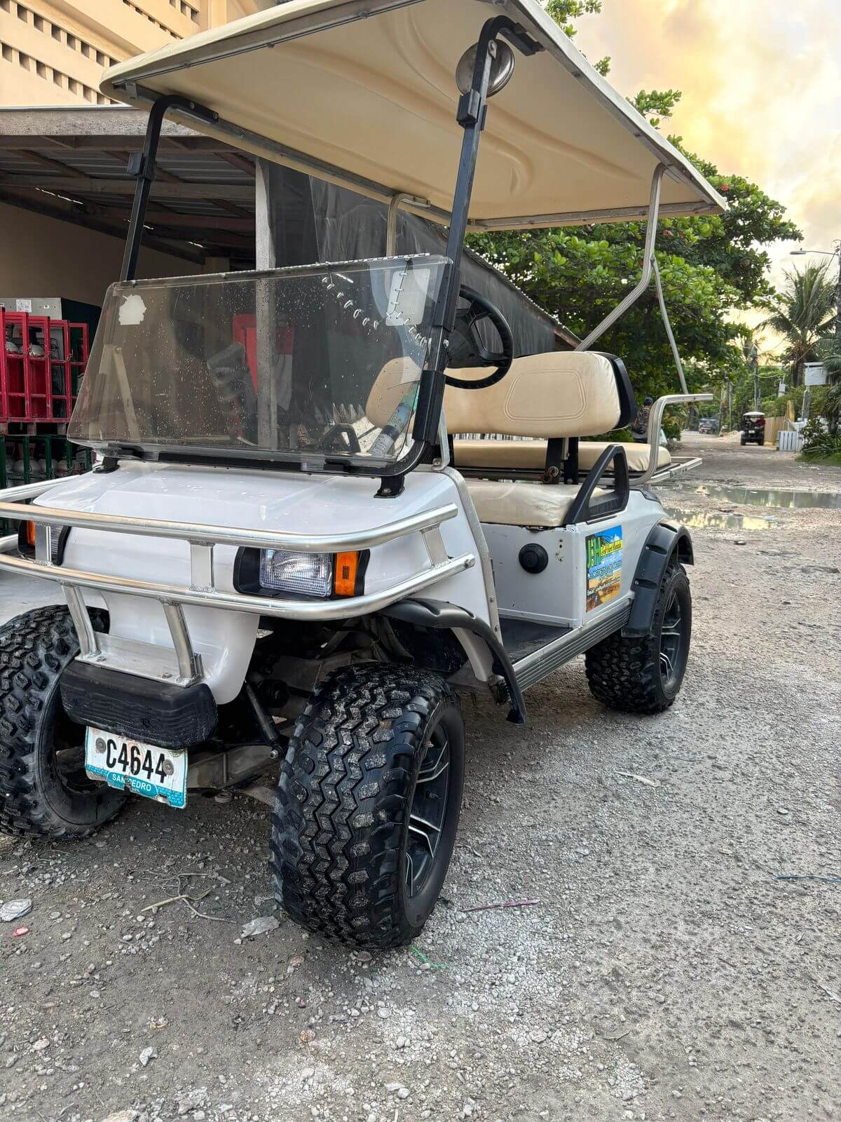 J&H-branded golf cart parked on a San Pedro paver street