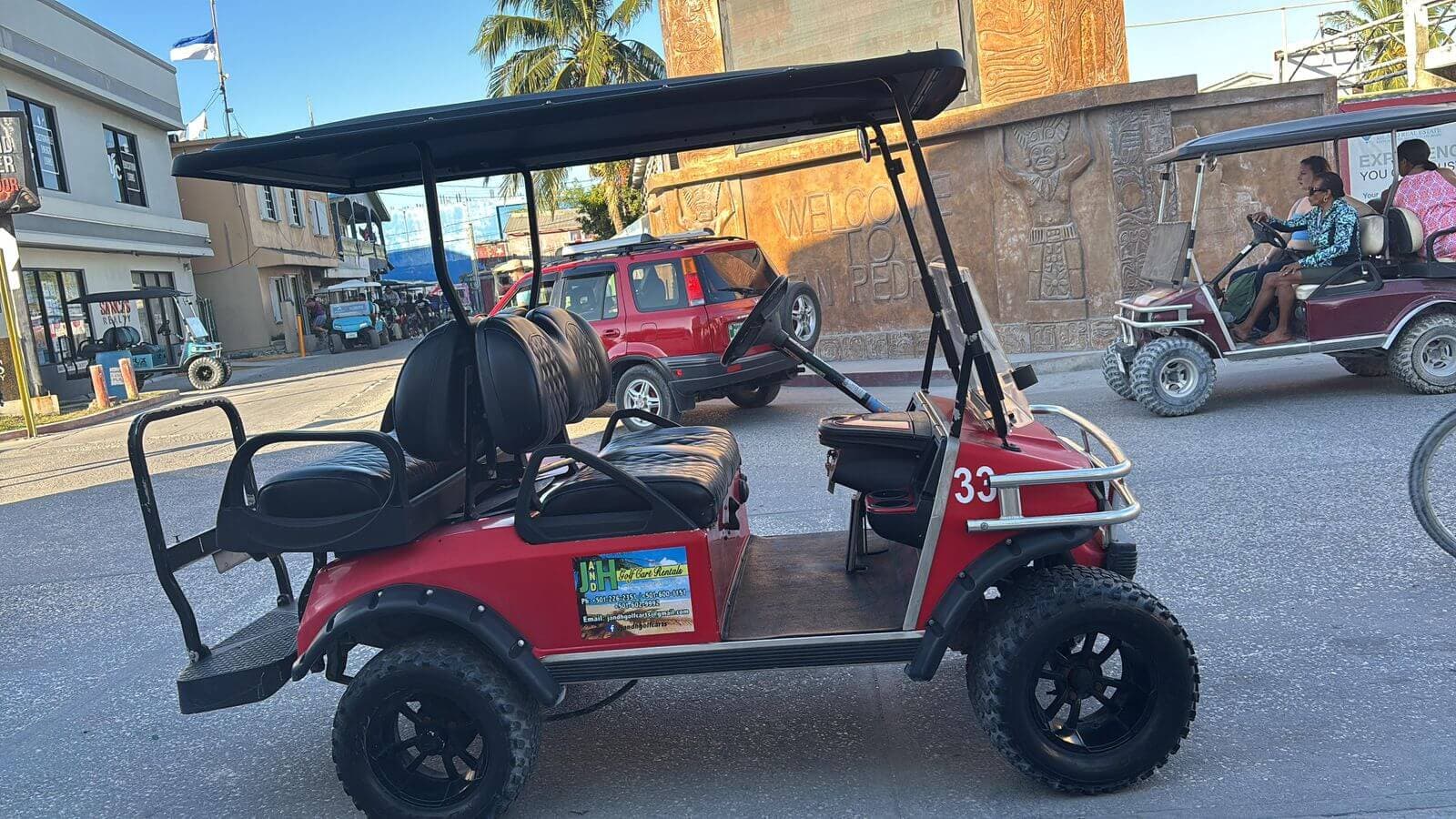Red 4-seater golf cart on a downtown San Pedro street