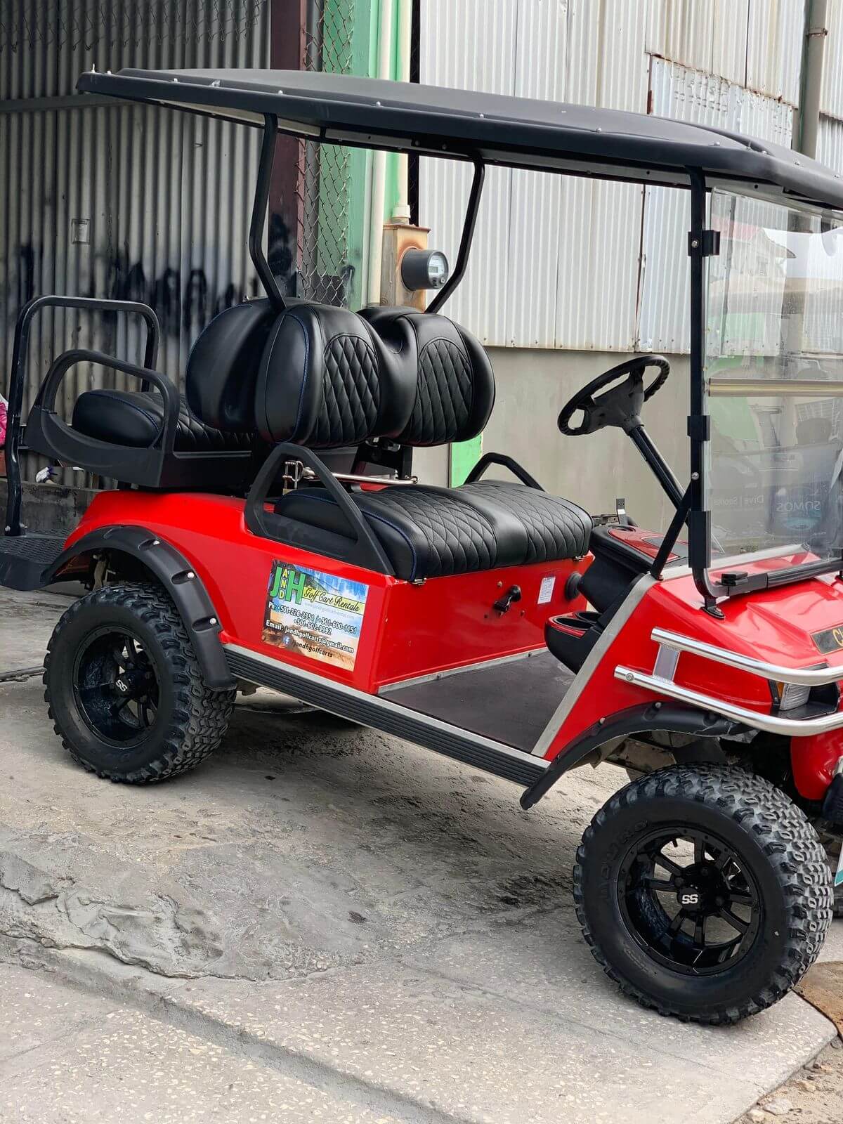 Red lifted golf cart with oversized wheels in San Pedro, Belize