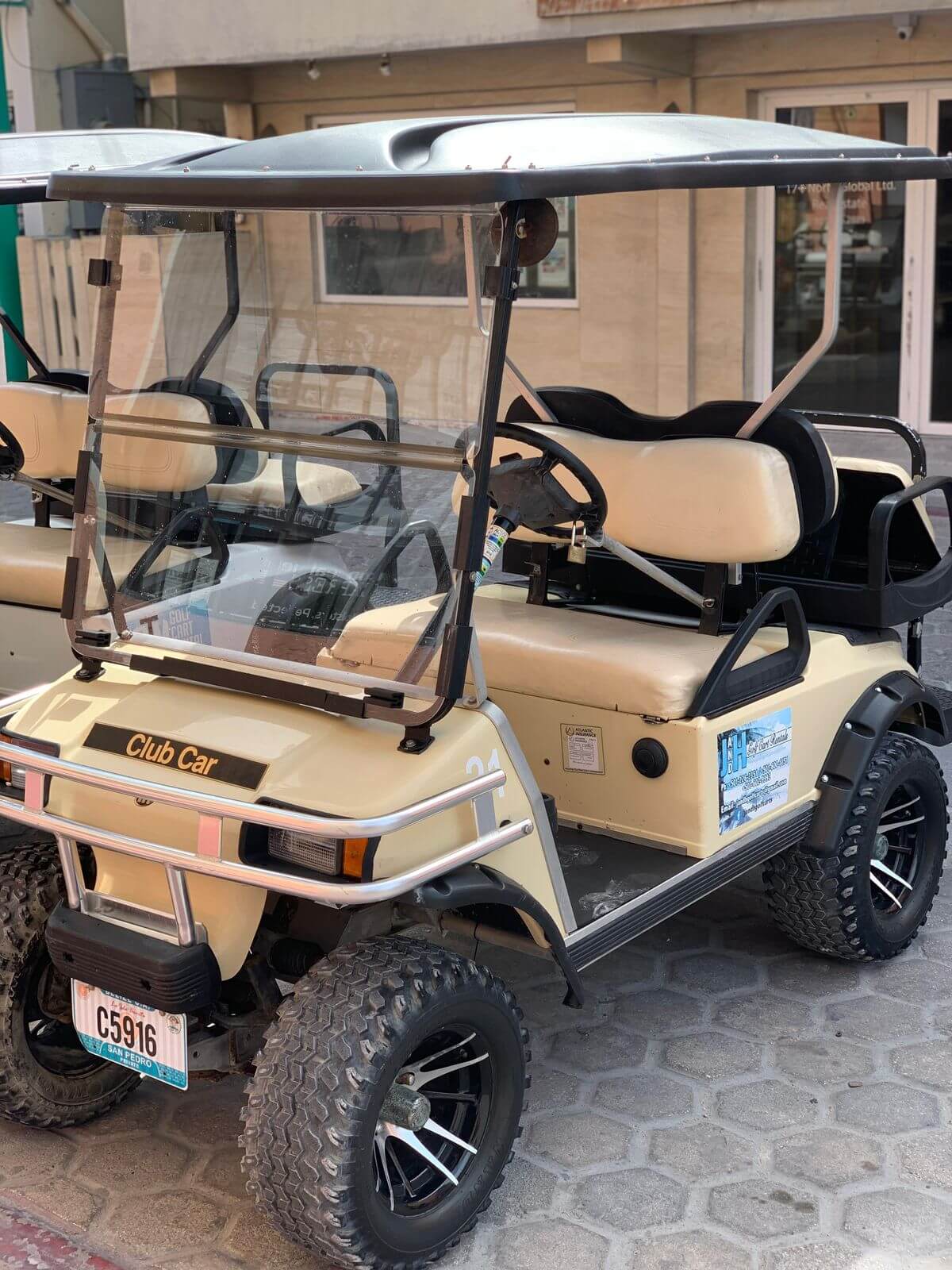 Tan golf cart rental parked in San Pedro, Belize
